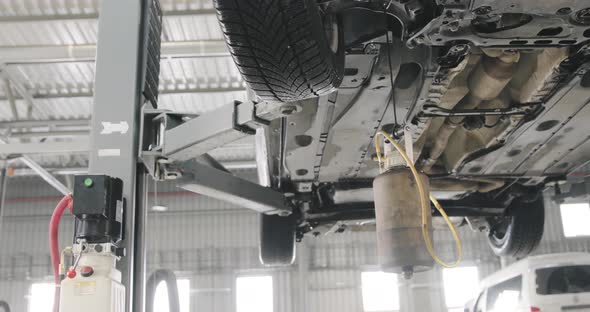 Mechanic Draining Old Brake Fluid From A System. Detail Shot Of The Canister. alt
