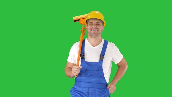 Housecleaner in helmet walking with a mop on a Green Screen alt