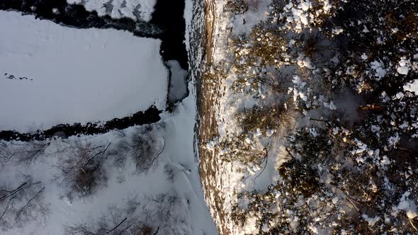 Trees On Top Of Cliff With Snowy Stream Below At Wintertime Near Bialka Tatrzanska, Poland. - aerial alt