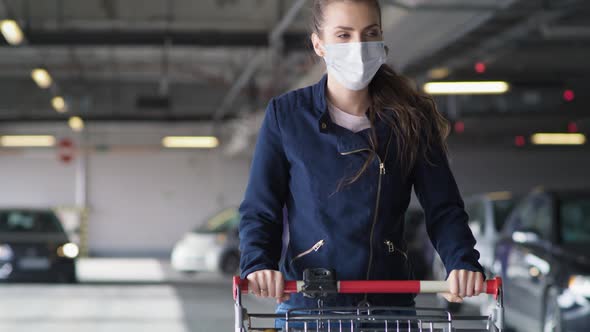Video of woman in protective mask with shopping cart. Shot with RED helium camera in 8K. alt