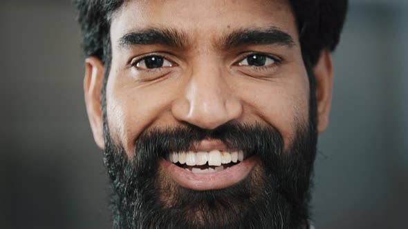 Close Up Male Arabian Bearded Face Handsome Man with Bright Brown Eyes Looking at Camera Smiling alt