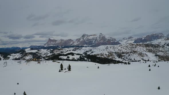 Aerial, Ski Facilities On Top Of Snowy Dolomites And Skiers In The Middle