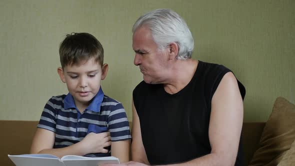 Grandfather and Grandson Reading a Book and Talking