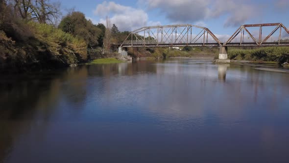 Drone flying backwards underneath new Truss bridge with old bridge in the background on Russian Rive alt