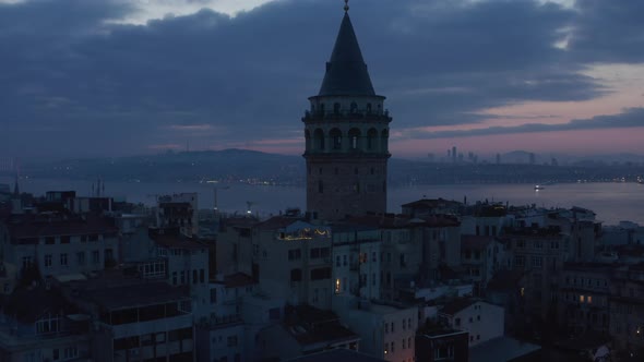 Establishing Shot of Galata Tower at Dark Blue Hour with Bosphorus in Background and Red Purple Sky alt