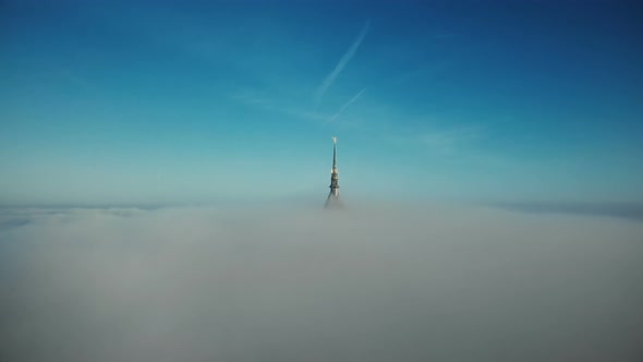 Drone Flying To and Above Mont Saint Michel Golden Castle Spire Covered By Thick Fog Mist Clouds in alt