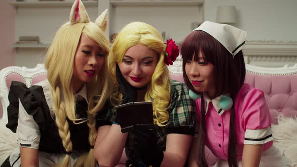 Cheerful Pretty Multiethnic Women in Cosplay Costume Viewing Old Photos alt