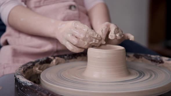 Little Girl Molding Wet Clay in Craft Studio Room alt