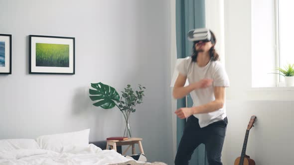 Man in Ar Glasses Playing War Video Game Shooting Gesturing in Bedroom at Home alt