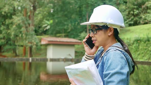 Female ecologist in safety hat working and controlling a quality of water. alt