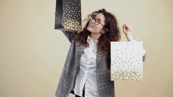 The Happy Young Woman Holds Two Cardboard Bags in Me Satisfied with the Purchases Made She Smiles alt