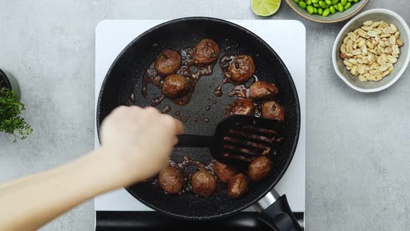 Woman cooking meatballs on frying pan with oil alt