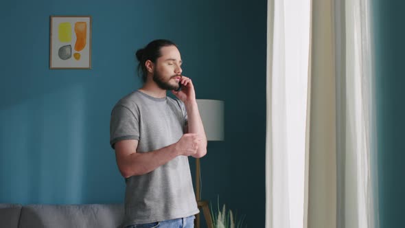 Man Is Talking on the Phone, Staring at Window alt