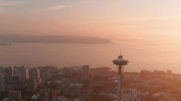 Wide aerial of the Space Needle during sunset with a layer of smoky haze over the Puget Sound. alt