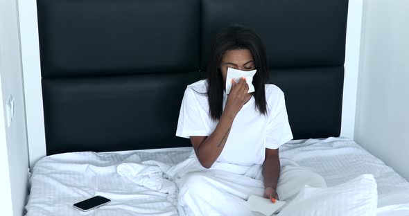 Sick black woman suffering from running stuffy nose.