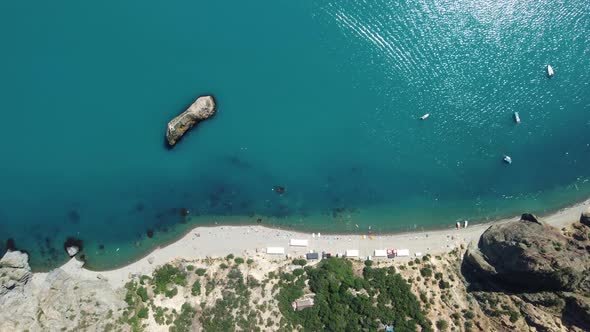 Aerial View From Above on Calm Azure Sea and Volcanic Rocky Shores alt