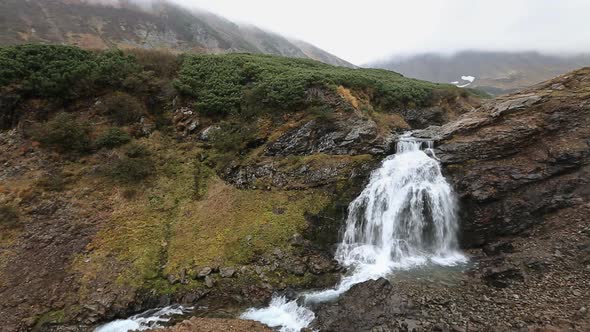 Mountain landscape: view of beautiful waterfall in autumn