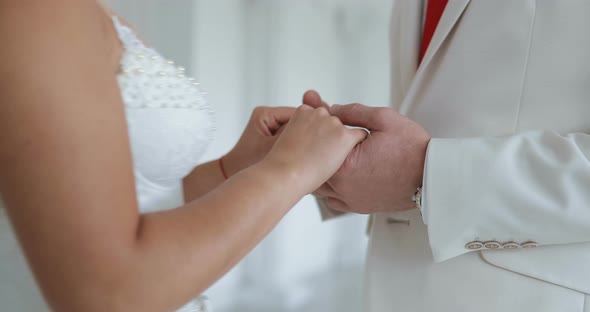 Bride and Groom Hold Hands and Look Each Other in the Eye alt