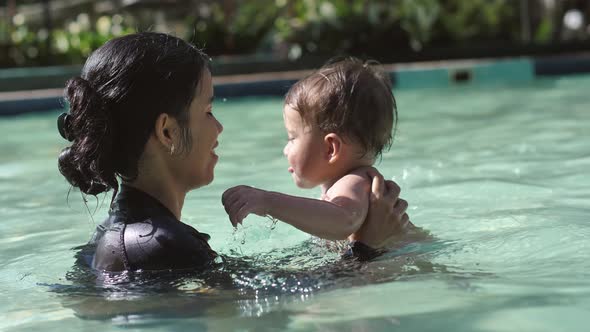 A Mother and Her Child a Child Less Than a Year Old Enjoy Swimming in the Pool