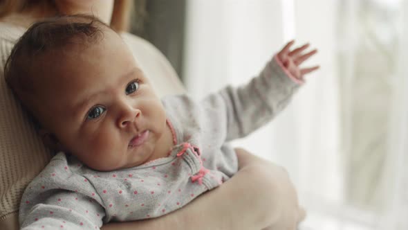 Infant Girl in Hands of Her Mother alt