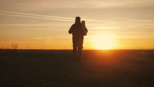 A Young Tourist Man with a Backpack Pictures Himself with a Phone. Against the Setting Sun. Slow alt