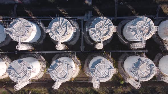 Aerial top down view of vertical white fuel storage tanks.