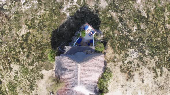 The Rock Restaurant in Ocean Built on Cliff at Low Tide on Zanzibar Aerial Top alt