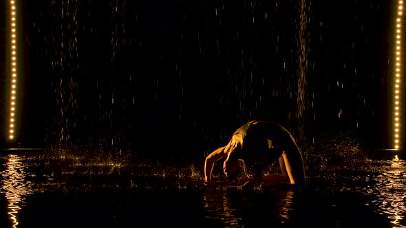 Silhouette of Attractive Woman Performing Bridge Pose. The Yellow Light Falls Softly on the Wet Body alt