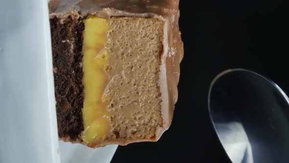 Steel Dessert Spoon Cuts Chocolate Brownie with Mango Filling alt