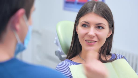 Smiling Patient Listening To Dentist's Advice in Dental Office