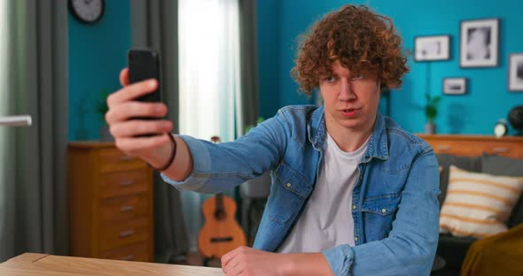 Teenager Male Use Smartphone Records Video for Social Networks Makes Funny Faces Flirts Laughs alt
