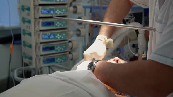 Anesthesist Performs an Intubation of the Patient Before the Operation alt