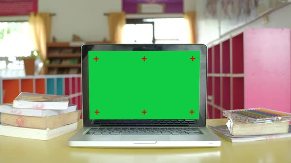 Chroma key green screen laptop computer set up for work at school.