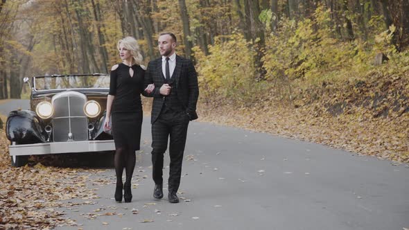 Romantic Couple Walking Under the Arms Foot to Foot in Park at Cabriolet alt