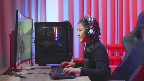 Cute Asian Girl Making Winner While Playing Car Race Video Game alt