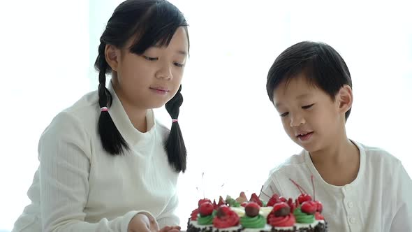 Asian Brother Feeding A Cake For His Sister alt