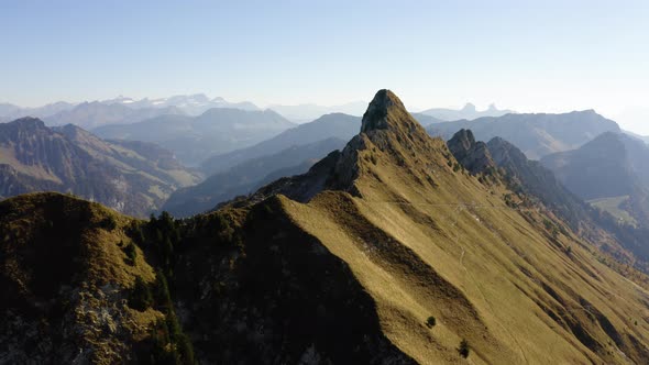 Aerial orbiting and climbing above summits. The Alps in the background and autumn colors"La Cape au alt