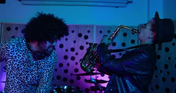 Young people dancing while mixing new album inside boutique recording studio alt