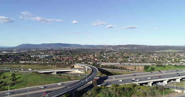 Slow accent over Eastlink highway on summer afternoon while a flock of birds fly around the drone. alt