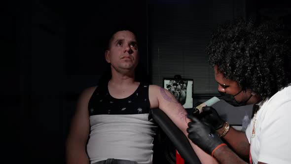 Cinematic Shot of a Tattoo Artist Creating Body Art at the Tattoo Studio alt