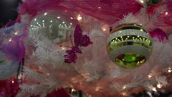 Panning view of christmas decorations on white tree alt
