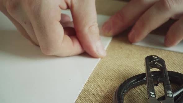 Close-up of the Master's Hands Make a Neat and Precise Fold of Paper for Making Patterns. Slow alt