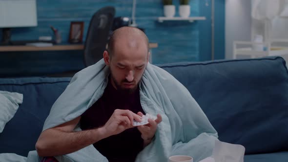 Unwell Man Holding Tablets with Capsules in Hand alt