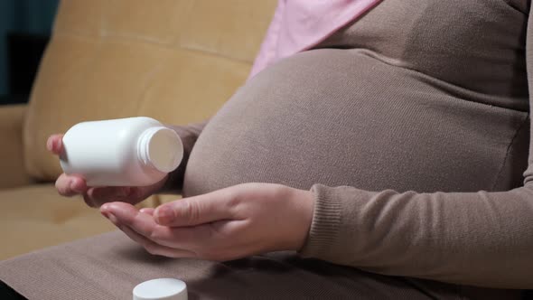 Pregnant Muslim Lady Drinks Vitamin Preparing for Childbirth alt