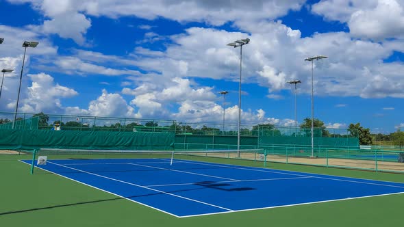 Time-lapse of outdoor empty tennis court with blue sky and cloud