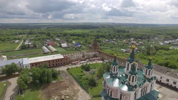 Aerial view of beautiful church in monastery surrounded by a brick wall alt