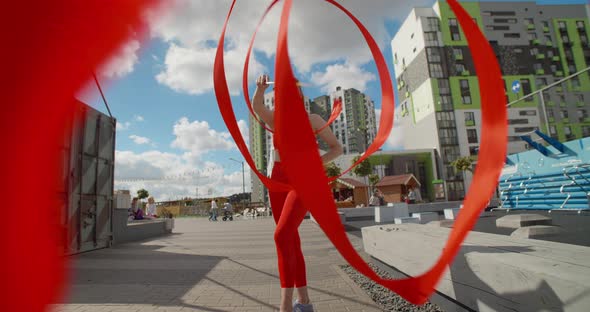 Young Woman in Red Performs Callisthenics with Ribbon at Workout Playground Outdoors, Gymnast Does alt