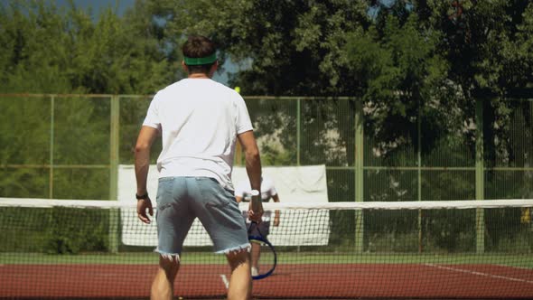 Sportsman Teaching Male Friend To Play Tennis