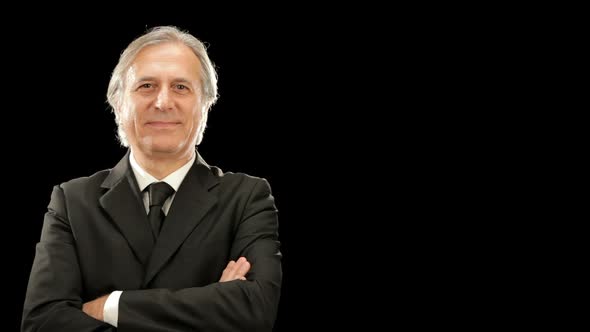 Middle Age Smiling Elegant Businessman is Looking at the Camera Isolated on Black