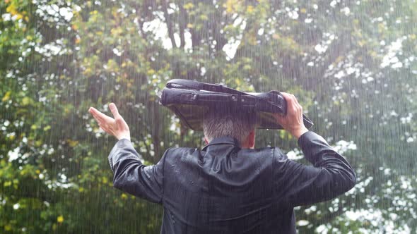 Businessman Sheltering Underneath his Bag in the Rain